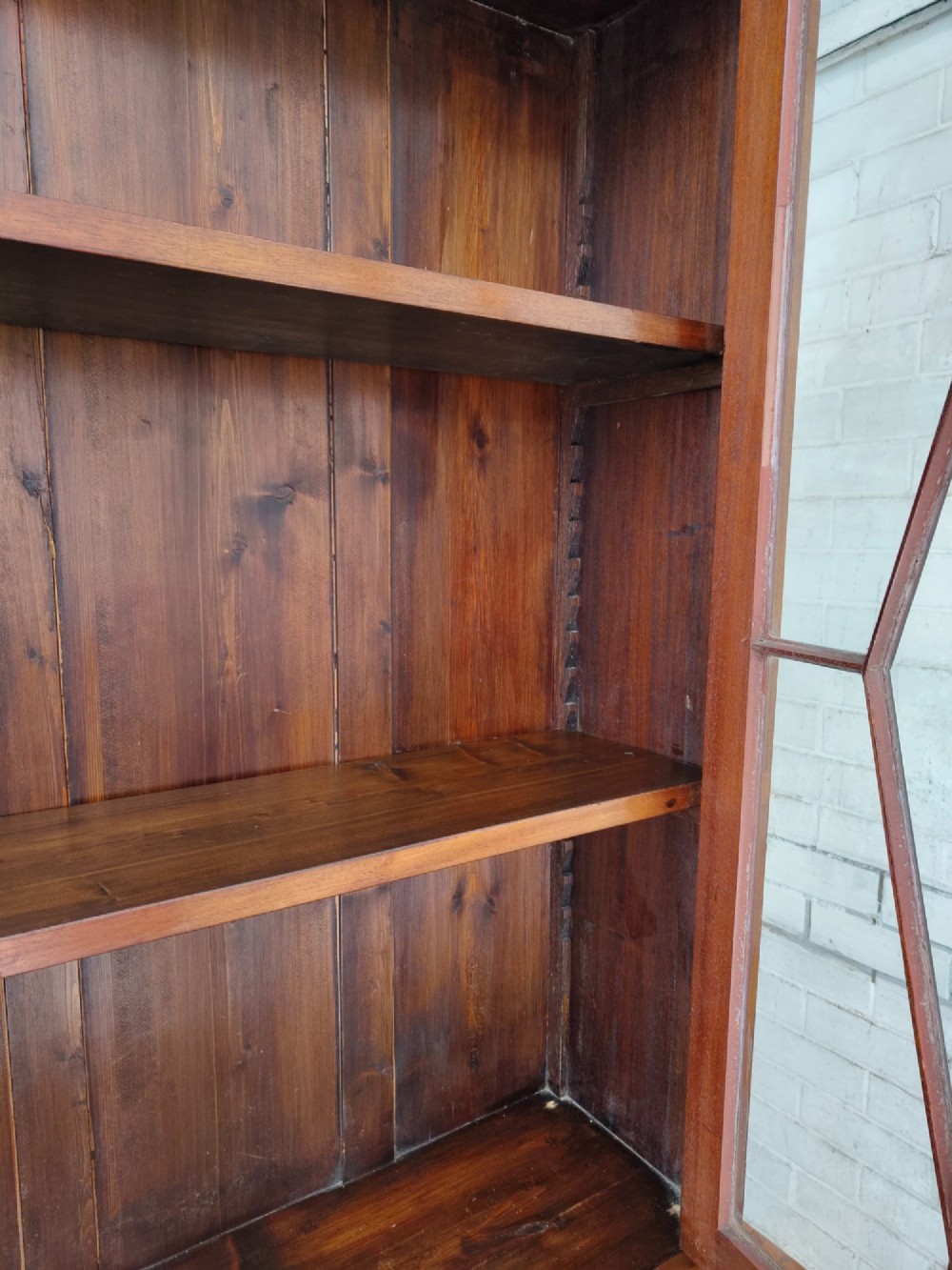 A tall Victorian mahogany bookcase featuring upper and lower double doors with diamond astragal glazed panels and adjustable interior shelves. View XI