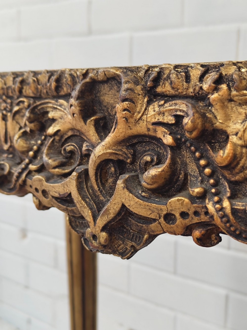 A diminutive French Louis XVI style giltwood console table with a red veined marble top, carved frieze, and slender tapered fluted legs. View IX
