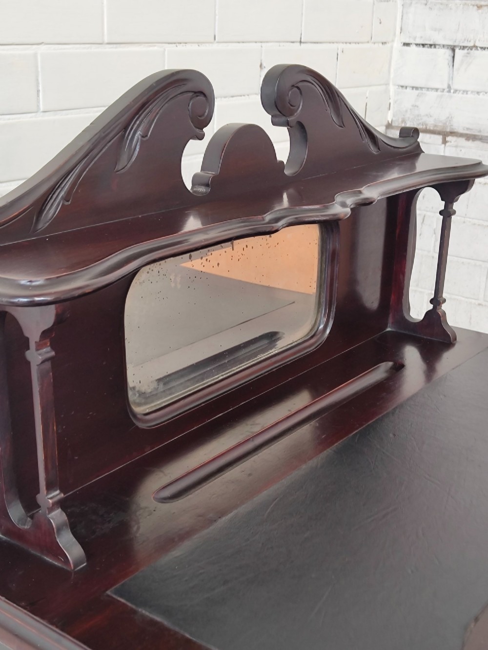 A dark mahogany Victorian ladies writing desk featuring slender cabriole legs, a single drawer, carved lattice details, and a raised back structure with a small central mirror. View IX