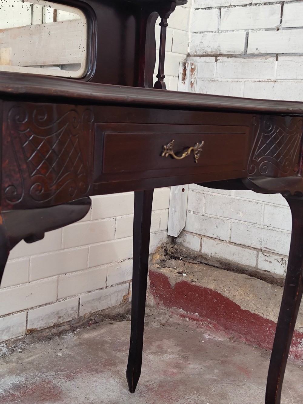 A dark mahogany Victorian ladies writing desk featuring slender cabriole legs, a single drawer, carved lattice details, and a raised back structure with a small central mirror. View XV