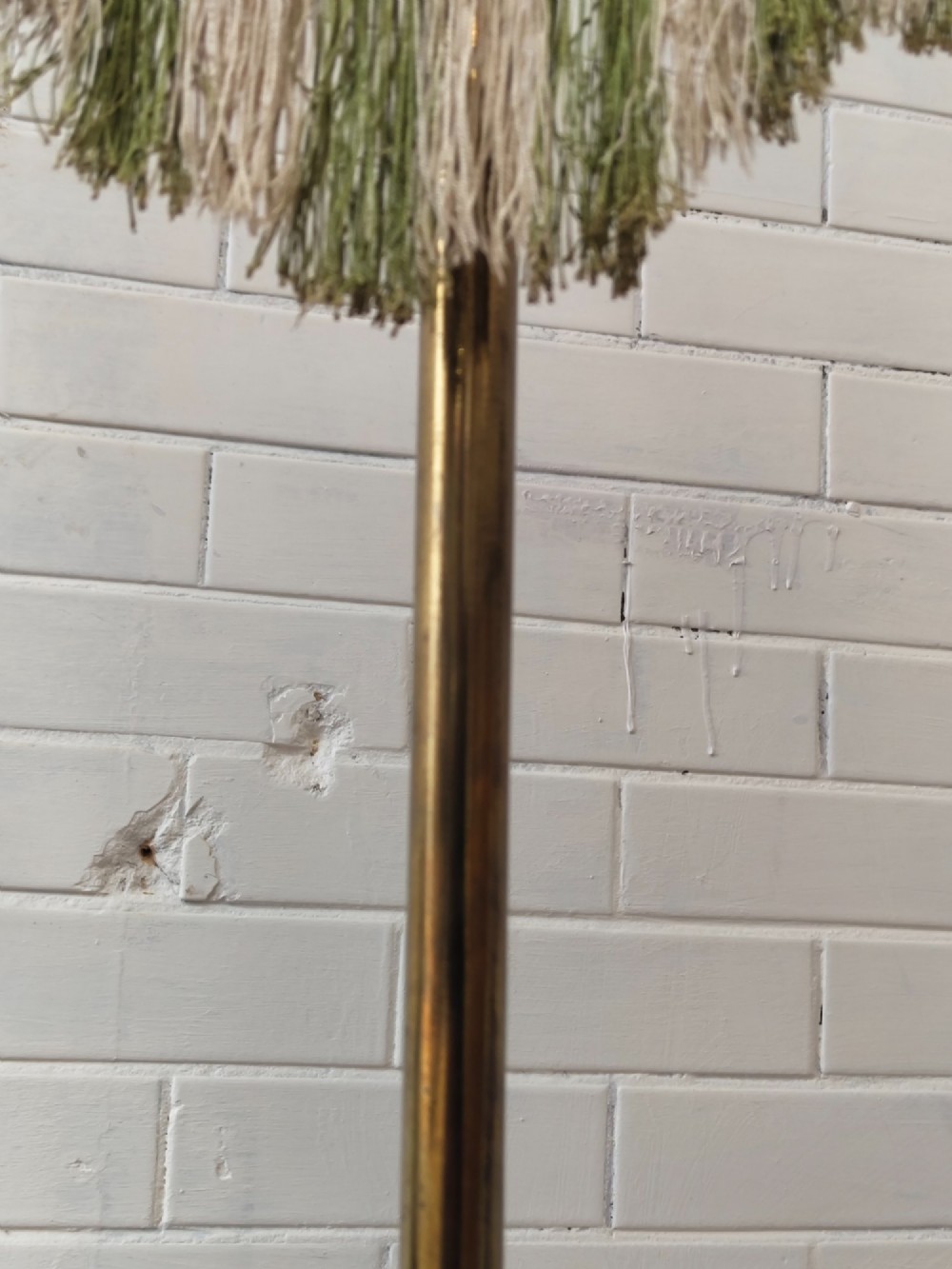 An antique Victorian brass pole screen featuring a green embroidered floral tapestry banner, fringed border, tassels, and a dark green velvet base. View V