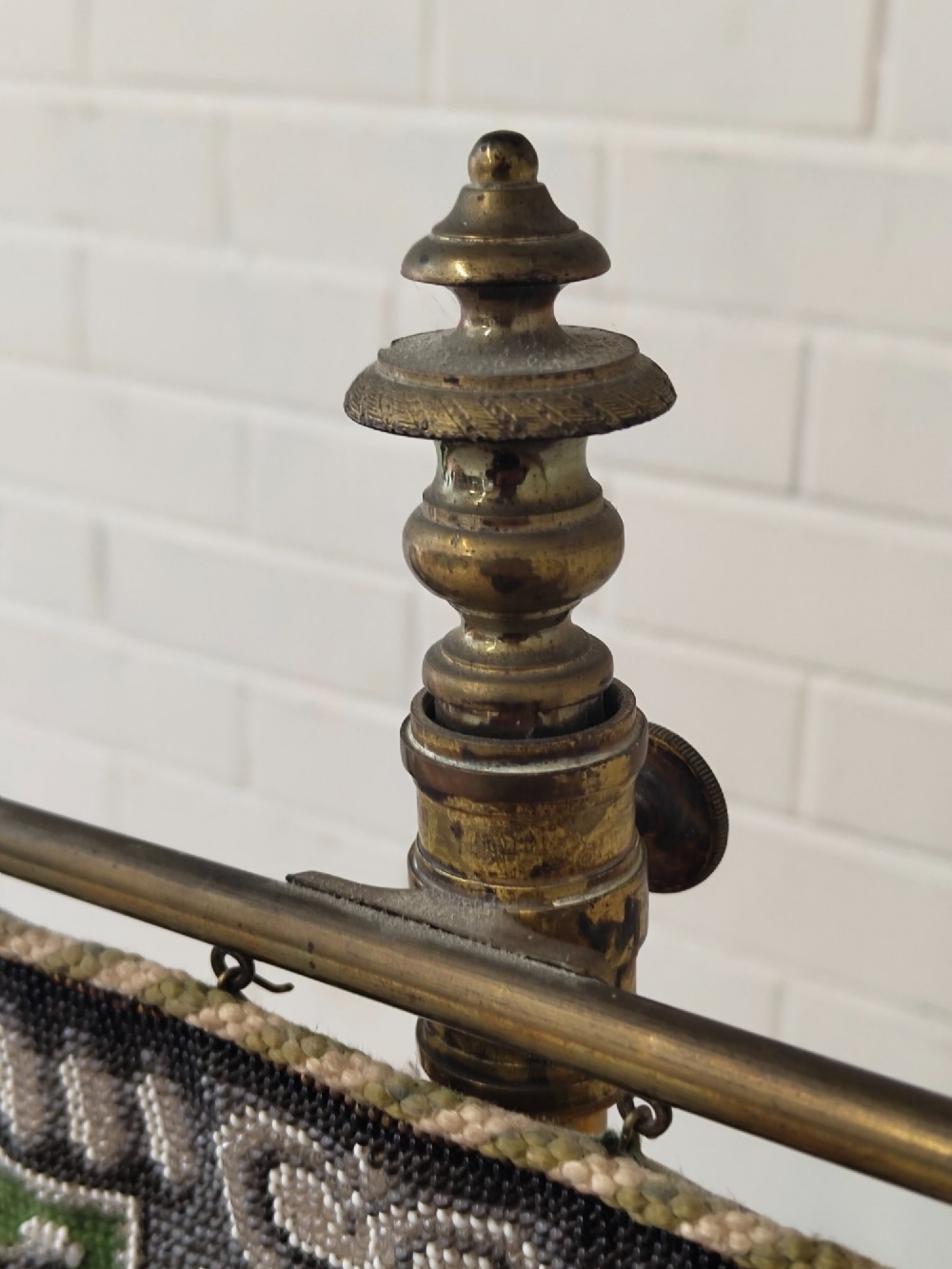 An antique Victorian brass pole screen featuring a green embroidered floral tapestry banner, fringed border, tassels, and a dark green velvet base. View IX