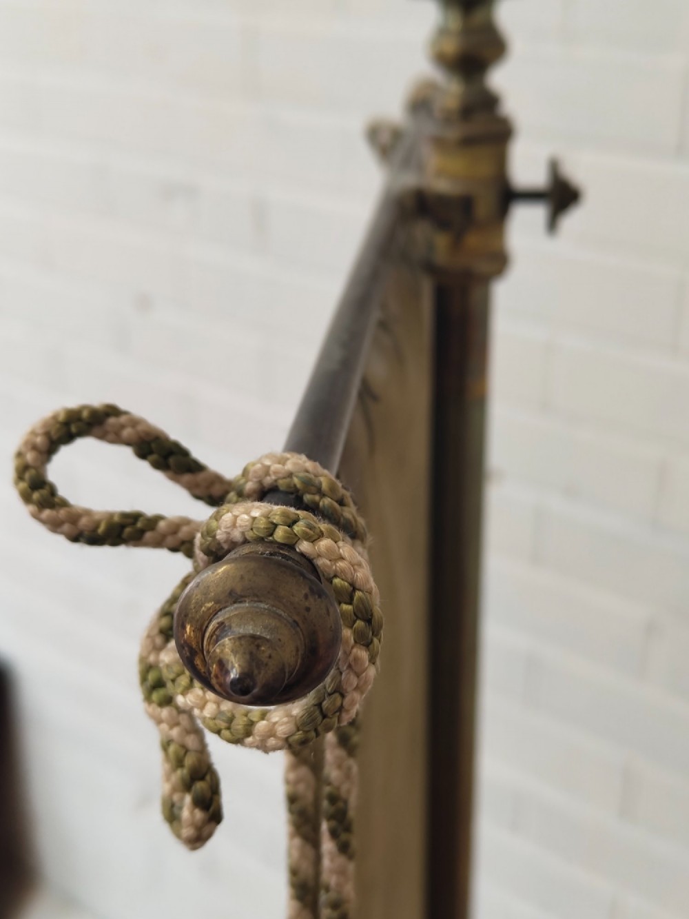 An antique Victorian brass pole screen featuring a green embroidered floral tapestry banner, fringed border, tassels, and a dark green velvet base. View XI
