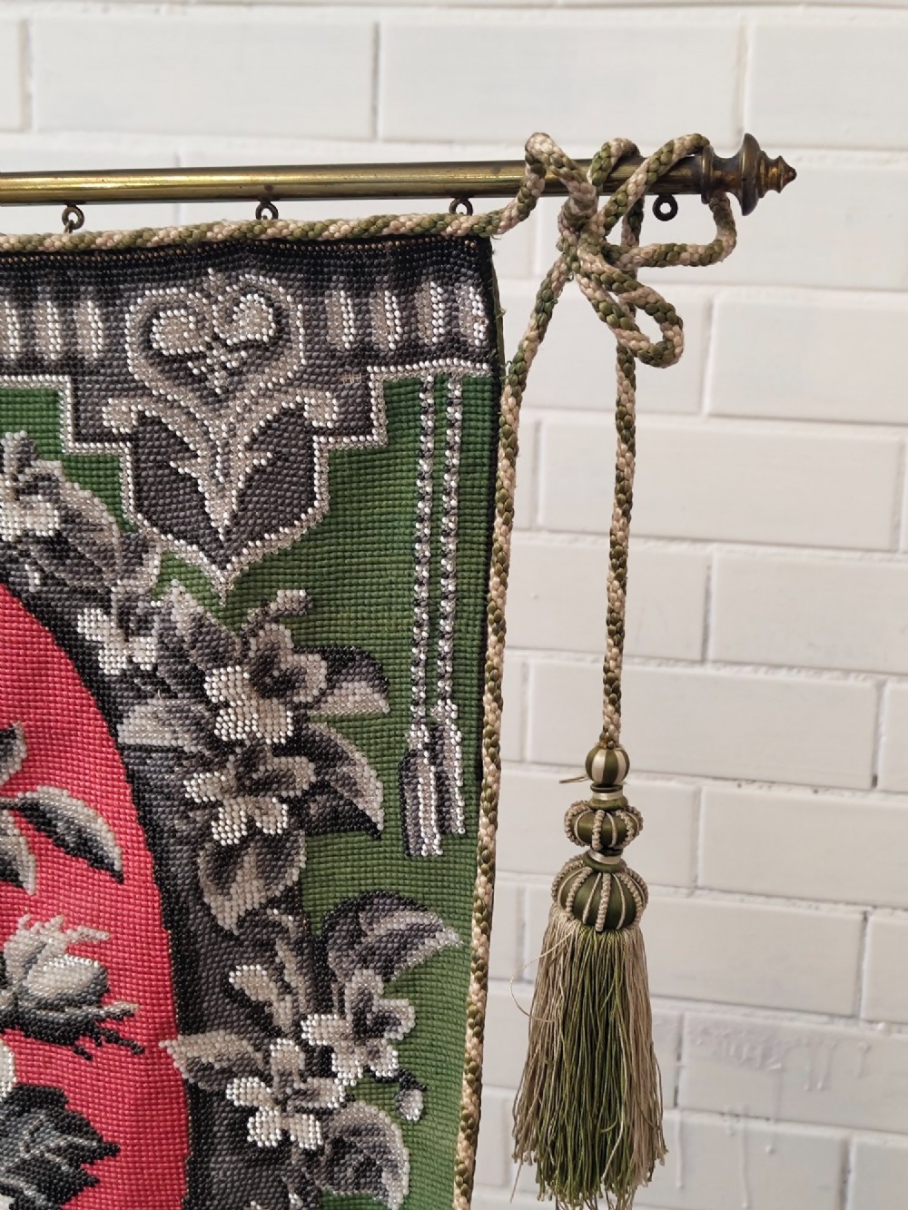 An antique Victorian brass pole screen featuring a green embroidered floral tapestry banner, fringed border, tassels, and a dark green velvet base. View XIII