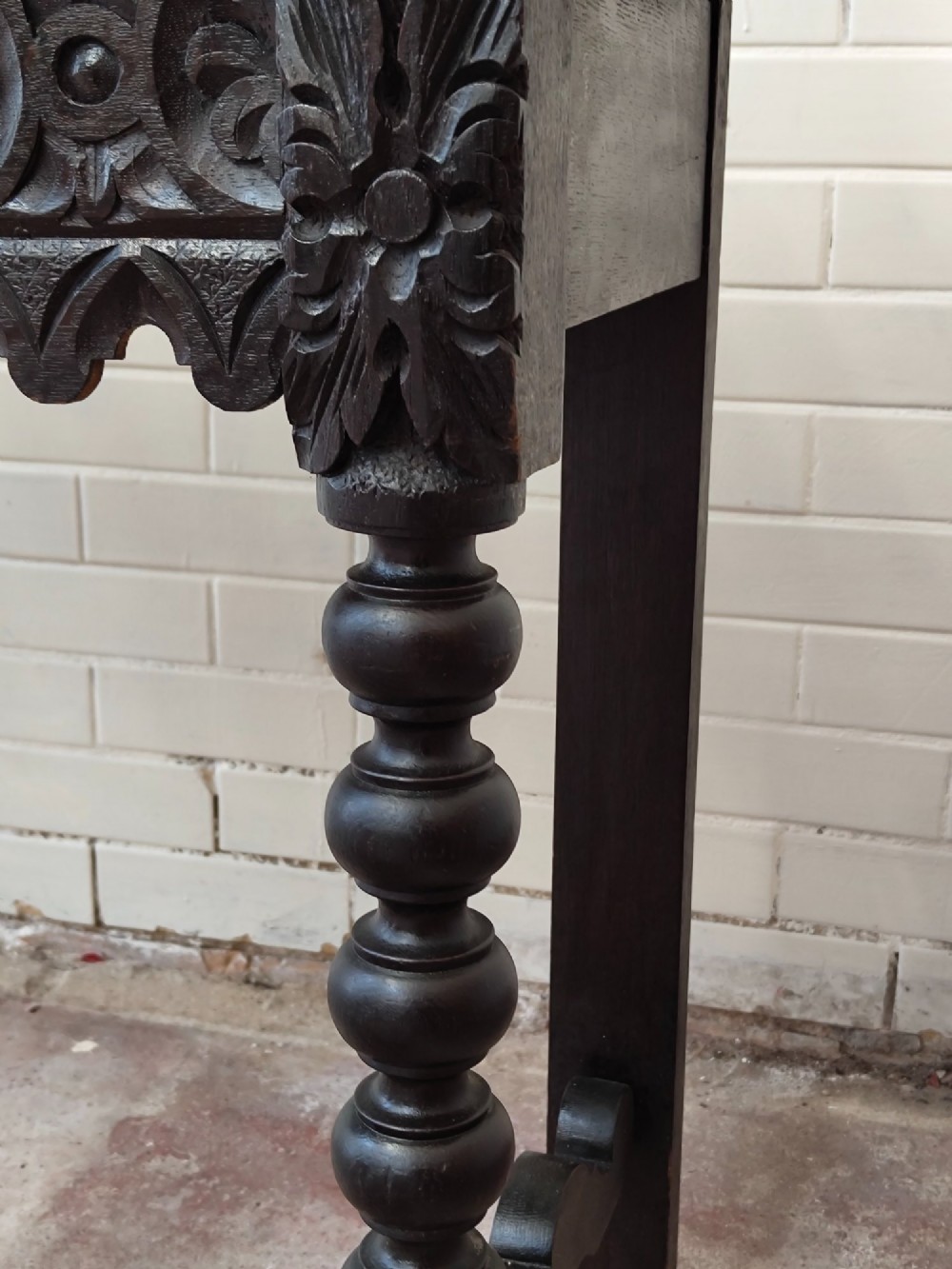Dark carved oak hall table featuring a carved floral gallery, relief apron, bobbin-turned front legs, and lower stretcher. View IV