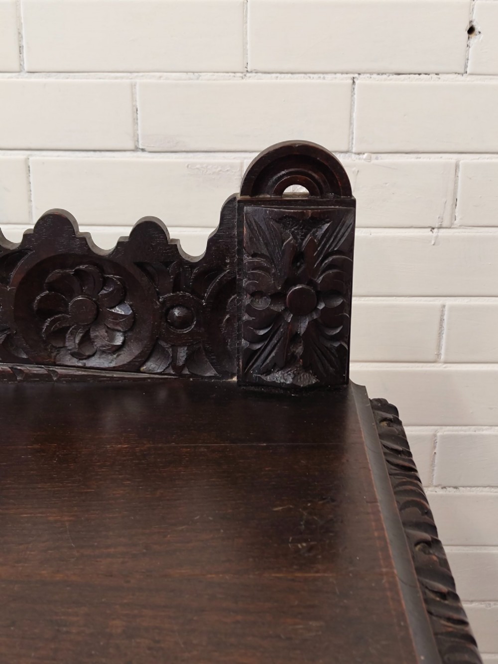 Dark carved oak hall table featuring a carved floral gallery, relief apron, bobbin-turned front legs, and lower stretcher. View VI