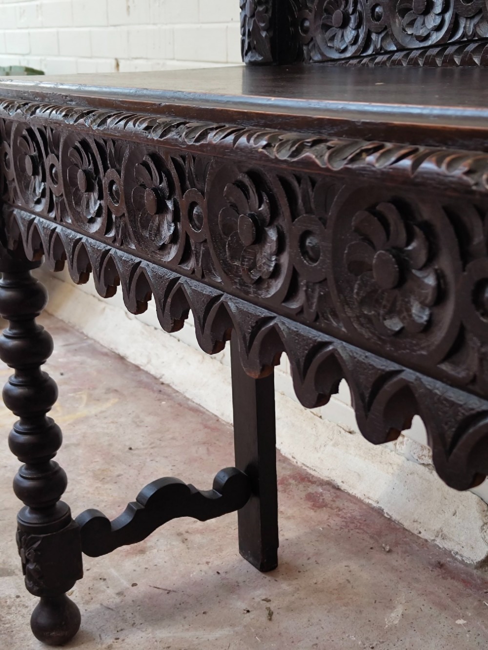 Dark carved oak hall table featuring a carved floral gallery, relief apron, bobbin-turned front legs, and lower stretcher. View VIII