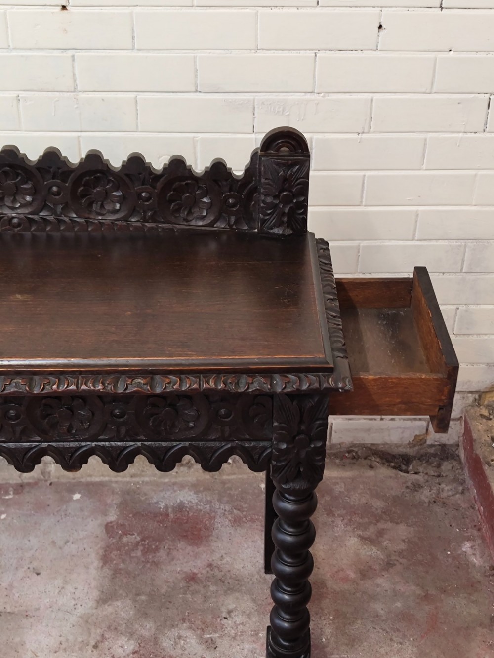 Dark carved oak hall table featuring a carved floral gallery, relief apron, bobbin-turned front legs, and lower stretcher. View IX