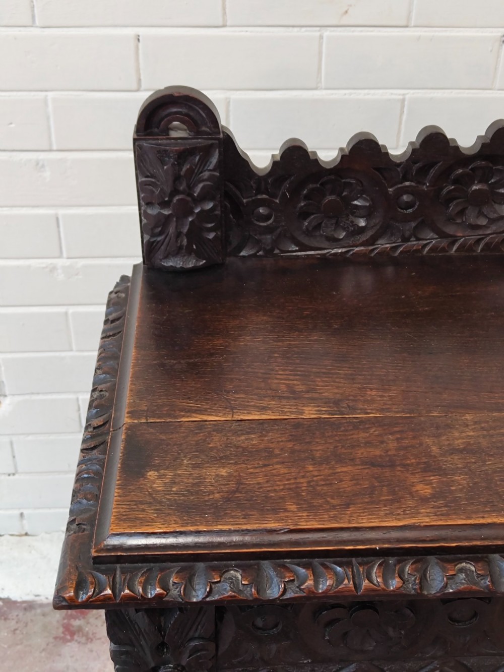 Dark carved oak hall table featuring a carved floral gallery, relief apron, bobbin-turned front legs, and lower stretcher. View XI