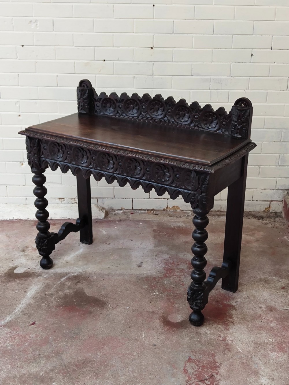 Dark carved oak hall table featuring a carved floral gallery, relief apron, bobbin-turned front legs, and lower stretcher. View XIII