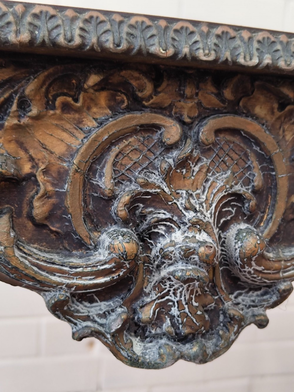 A diminutive French Rococo style console table featuring slender gilt cabriole legs, carved aprons, and a dark faux marble top. View VII