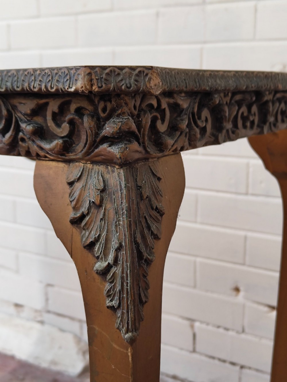 A diminutive French Rococo style console table featuring slender gilt cabriole legs, carved aprons, and a dark faux marble top. View XII
