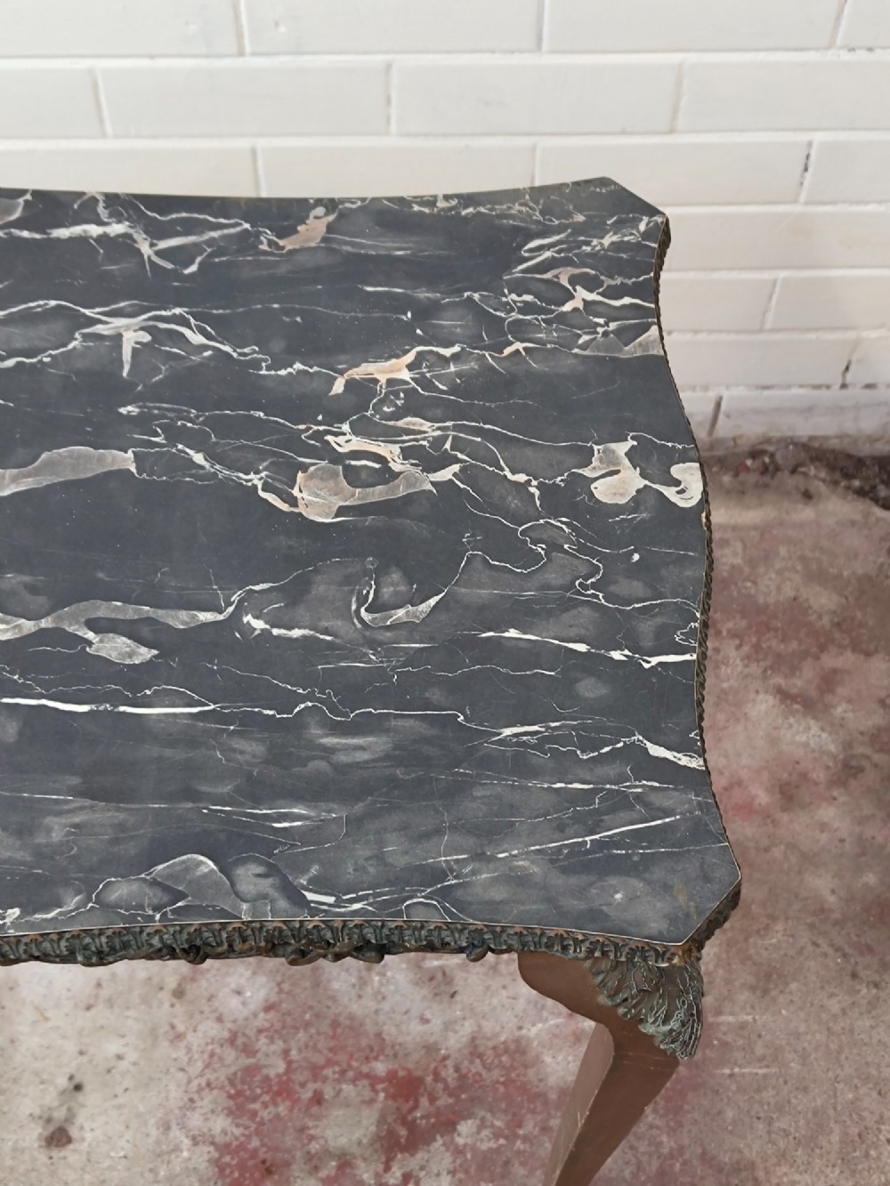 A diminutive French Rococo style console table featuring slender gilt cabriole legs, carved aprons, and a dark faux marble top. View XIII