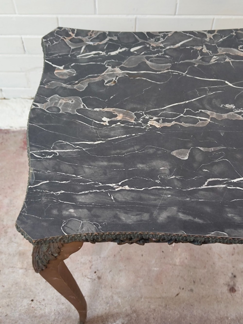 A diminutive French Rococo style console table featuring slender gilt cabriole legs, carved aprons, and a dark faux marble top. View XIV