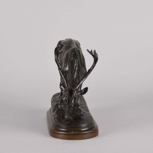 fig 2. A 19th-century dark brown patinated bronze sculpture depicting a grazing reindeer with branching antlers on an oval naturalistic base.