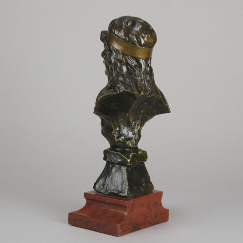 fig 6. An Art Nouveau patinated bronze bust of a young woman with long hair and a headband mounted on a red marble base.