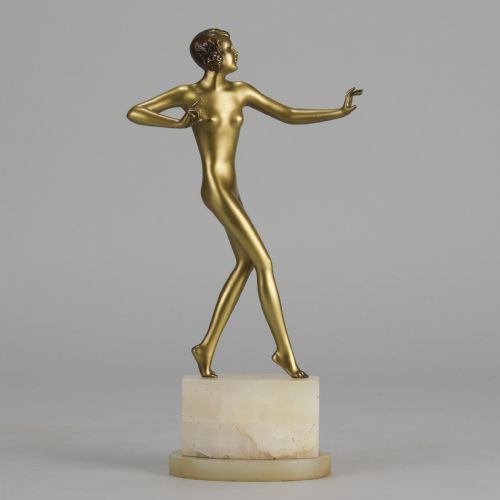fig 1. An Art Deco cold-painted bronze figurine depicting a slender female dancer posed on a square onyx base.