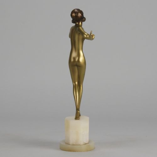 fig 6. An Art Deco cold-painted bronze figurine depicting a slender female dancer posed on a square onyx base.