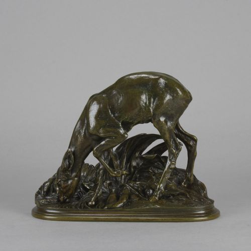 fig 1. A dark patinated bronze sculpture depicting a doe bending down to drink amongst naturalistic foliage on an oval base.
