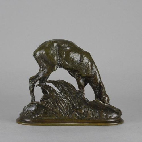 fig 3. A dark patinated bronze sculpture depicting a doe bending down to drink amongst naturalistic foliage on an oval base.