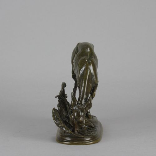 fig 4. A dark patinated bronze sculpture depicting a doe bending down to drink amongst naturalistic foliage on an oval base.