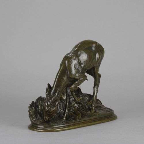 fig 5. A dark patinated bronze sculpture depicting a doe bending down to drink amongst naturalistic foliage on an oval base.