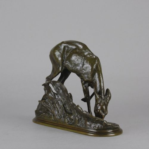 fig 6. A dark patinated bronze sculpture depicting a doe bending down to drink amongst naturalistic foliage on an oval base.