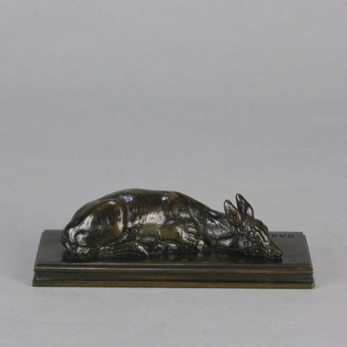 fig 1. A dark brown patinated bronze sculpture depicting a reclining doe resting on a rectangular bronze base signed Barye.