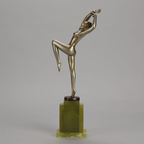 fig 1. An Art Deco cold-painted bronze sculpture of a female dancer balanced on one foot, mounted on a stepped green onyx plinth base.