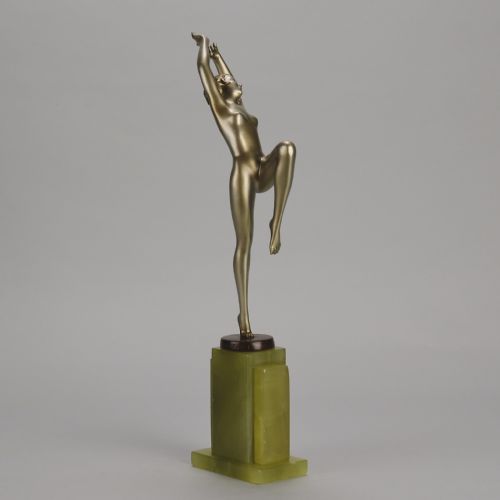 fig 3. An Art Deco cold-painted bronze sculpture of a female dancer balanced on one foot, mounted on a stepped green onyx plinth base.