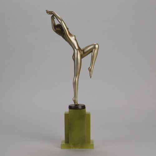 fig 4. An Art Deco cold-painted bronze sculpture of a female dancer balanced on one foot, mounted on a stepped green onyx plinth base.