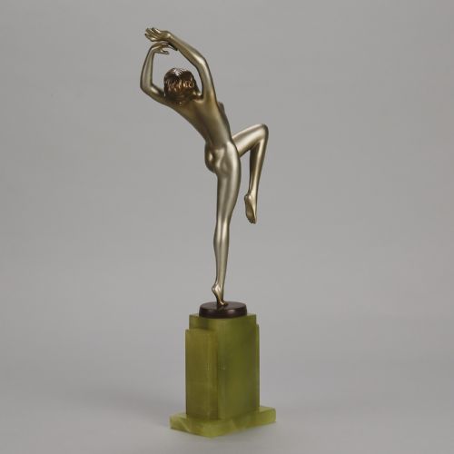 fig 5. An Art Deco cold-painted bronze sculpture of a female dancer balanced on one foot, mounted on a stepped green onyx plinth base.