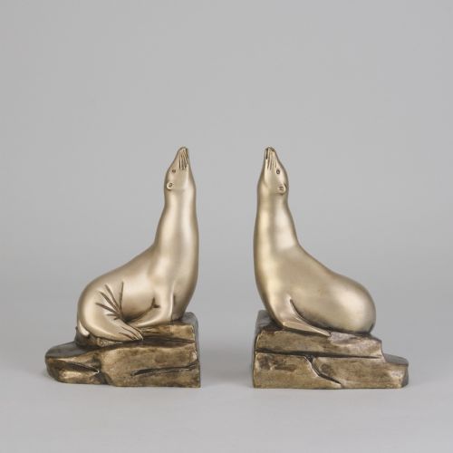 fig 1. A pair of bronze Art Deco bookends shaped as sea lions resting on rocky bases with heads raised.