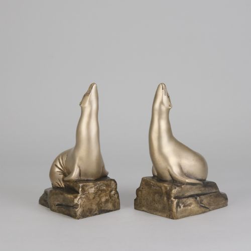 fig 2. A pair of bronze Art Deco bookends shaped as sea lions resting on rocky bases with heads raised.