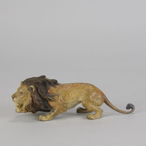 fig 1. An early 20th-century cold-painted bronze figurine depicting a crouching lion with a dark brown mane and ochre coat.