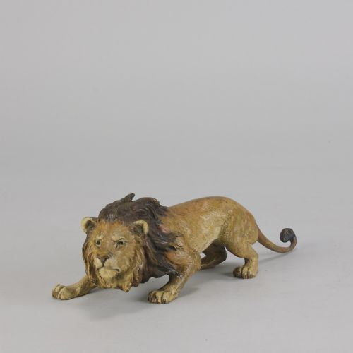 fig 2. An early 20th-century cold-painted bronze figurine depicting a crouching lion with a dark brown mane and ochre coat.