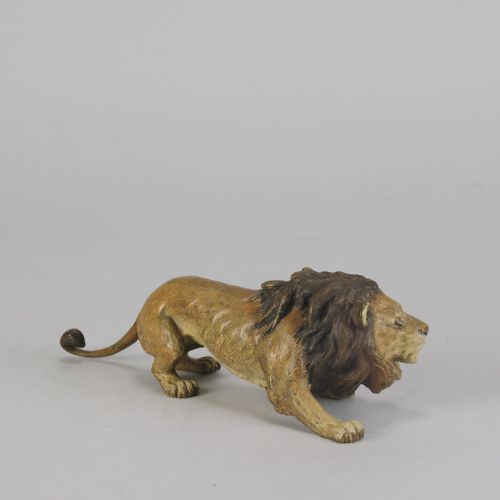 fig 4. An early 20th-century cold-painted bronze figurine depicting a crouching lion with a dark brown mane and ochre coat.