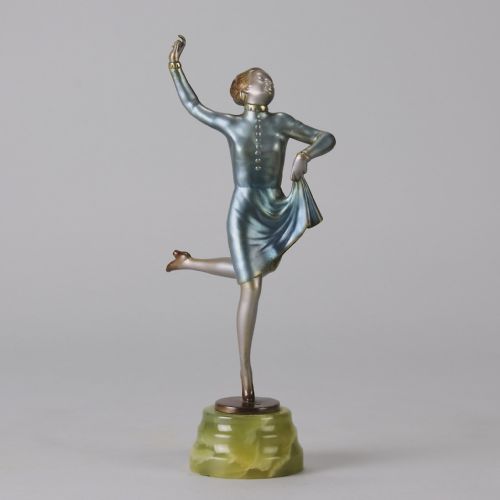 fig 1. An Art Deco cold-painted bronze figurine depicting a female dancer poised on one foot atop a carved green onyx pedestal.