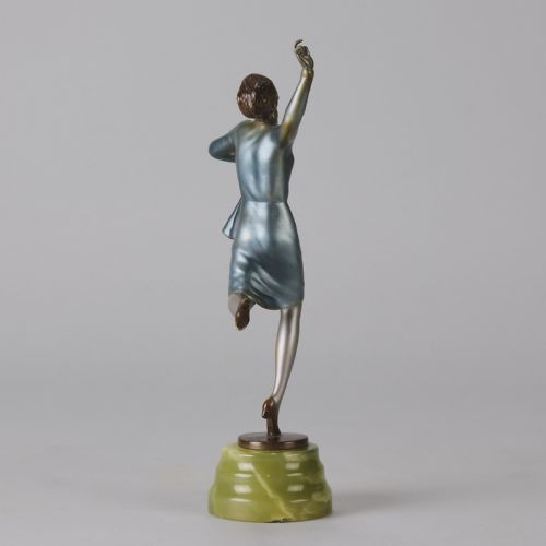 fig 4. An Art Deco cold-painted bronze figurine depicting a female dancer poised on one foot atop a carved green onyx pedestal.