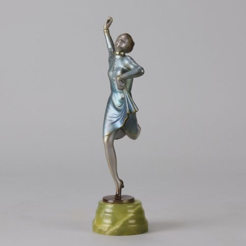 fig 8. An Art Deco cold-painted bronze figurine depicting a female dancer poised on one foot atop a carved green onyx pedestal.