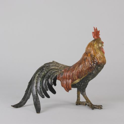 fig 4. A cold-painted bronze figurine depicting a standing cockerel with a red comb and textured feathers in brown, ochre, and dark grey shades.