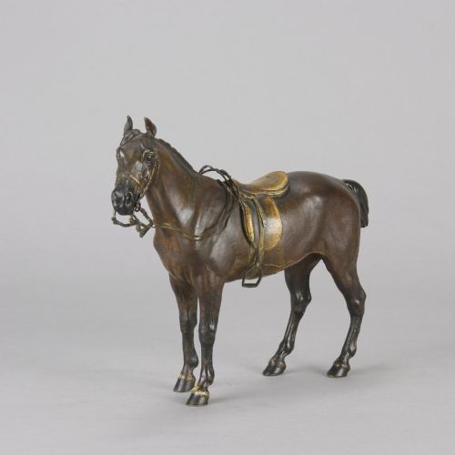 fig 3. A cold-painted bronze sculpture depicting a saddled horse with gold-coloured tack, bridle, and stirrups in a standing pose.