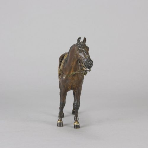 fig 4. A cold-painted bronze sculpture depicting a saddled horse with gold-coloured tack, bridle, and stirrups in a standing pose.