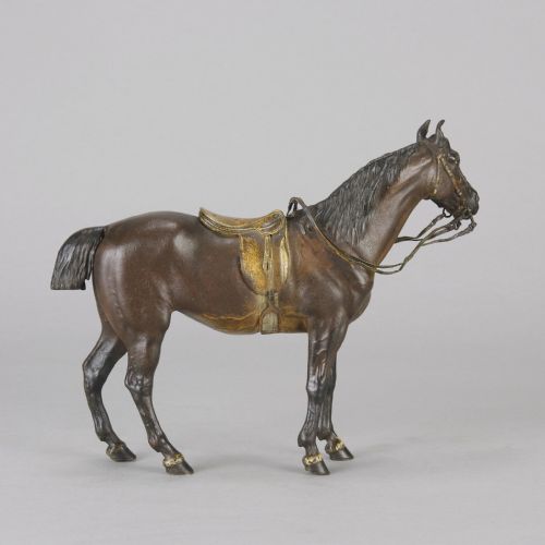 fig 5. A cold-painted bronze sculpture depicting a saddled horse with gold-coloured tack, bridle, and stirrups in a standing pose.