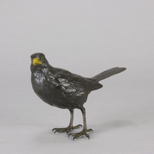 fig 2. An early 20th-century cold-painted bronze figurine depicting a standing blackbird with dark plumage and a bright yellow beak.
