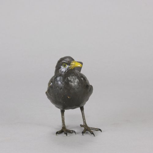 fig 4. An early 20th-century cold-painted bronze figurine depicting a standing blackbird with dark plumage and a bright yellow beak.