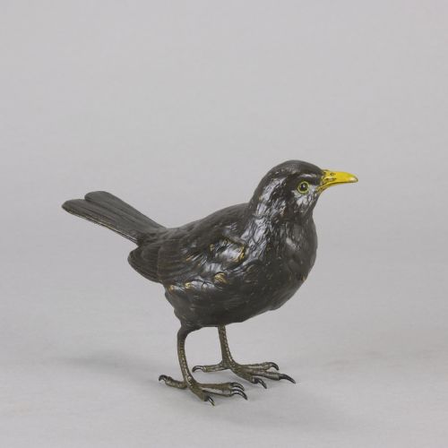 fig 5. An early 20th-century cold-painted bronze figurine depicting a standing blackbird with dark plumage and a bright yellow beak.