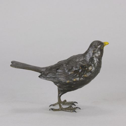 fig 6. An early 20th-century cold-painted bronze figurine depicting a standing blackbird with dark plumage and a bright yellow beak.