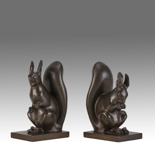 fig 1. A pair of early 20th-century dark brown cast bronze bookends featuring seated squirrels with raised tails mounted on rectangular bases.