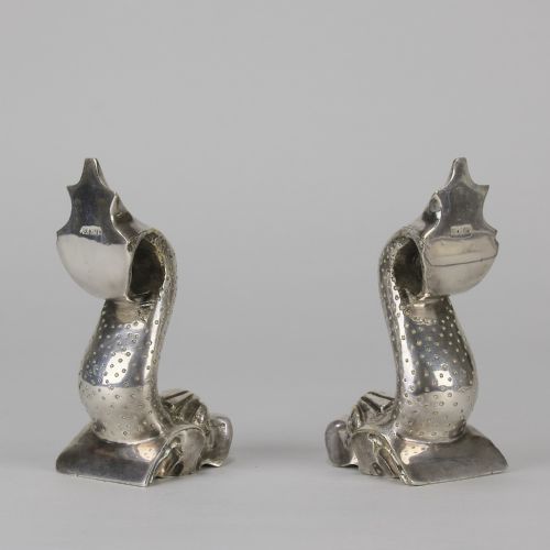 fig 3. A pair of silvered metal bookends sculpted in the shape of upright stylised fish with textured scales and curved tails.
